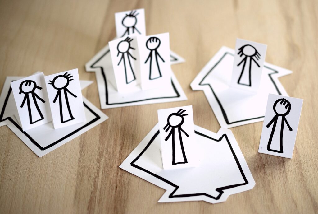personnages en papier disposés sur des flèches ou maisons en papeir