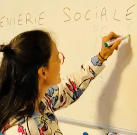 Photo adhérente qui inscrit sur un tableau l'expression ingénierie sociale